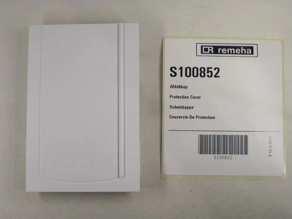 Weiße Schutzkappe von Remeha neben Verpackung, die die Artikelnummer S100852 und mehrsprachige Produktbezeichnungen zeigt.